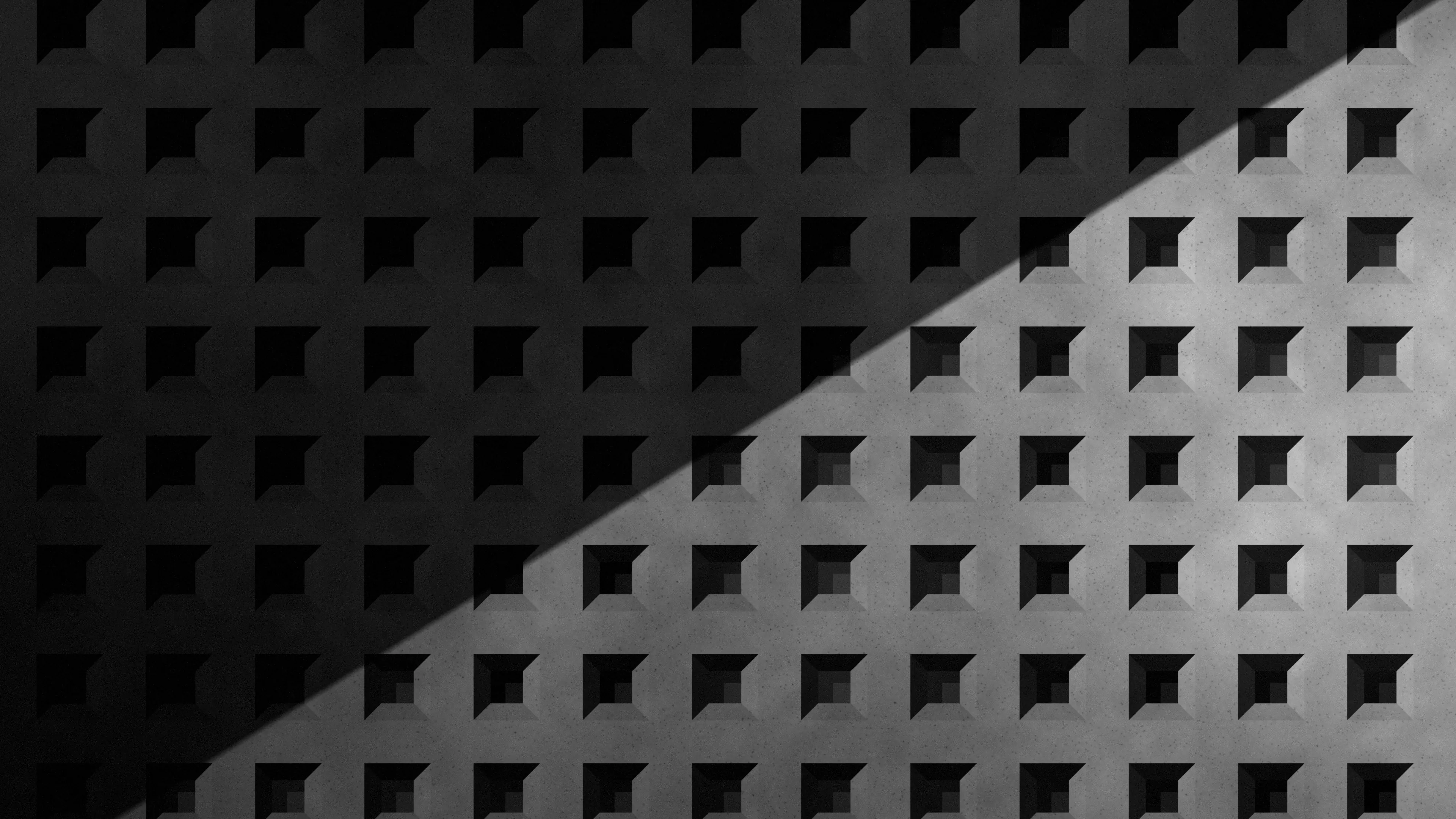 Retícula de hormigón con una diagonal de luz, en blanco y negro