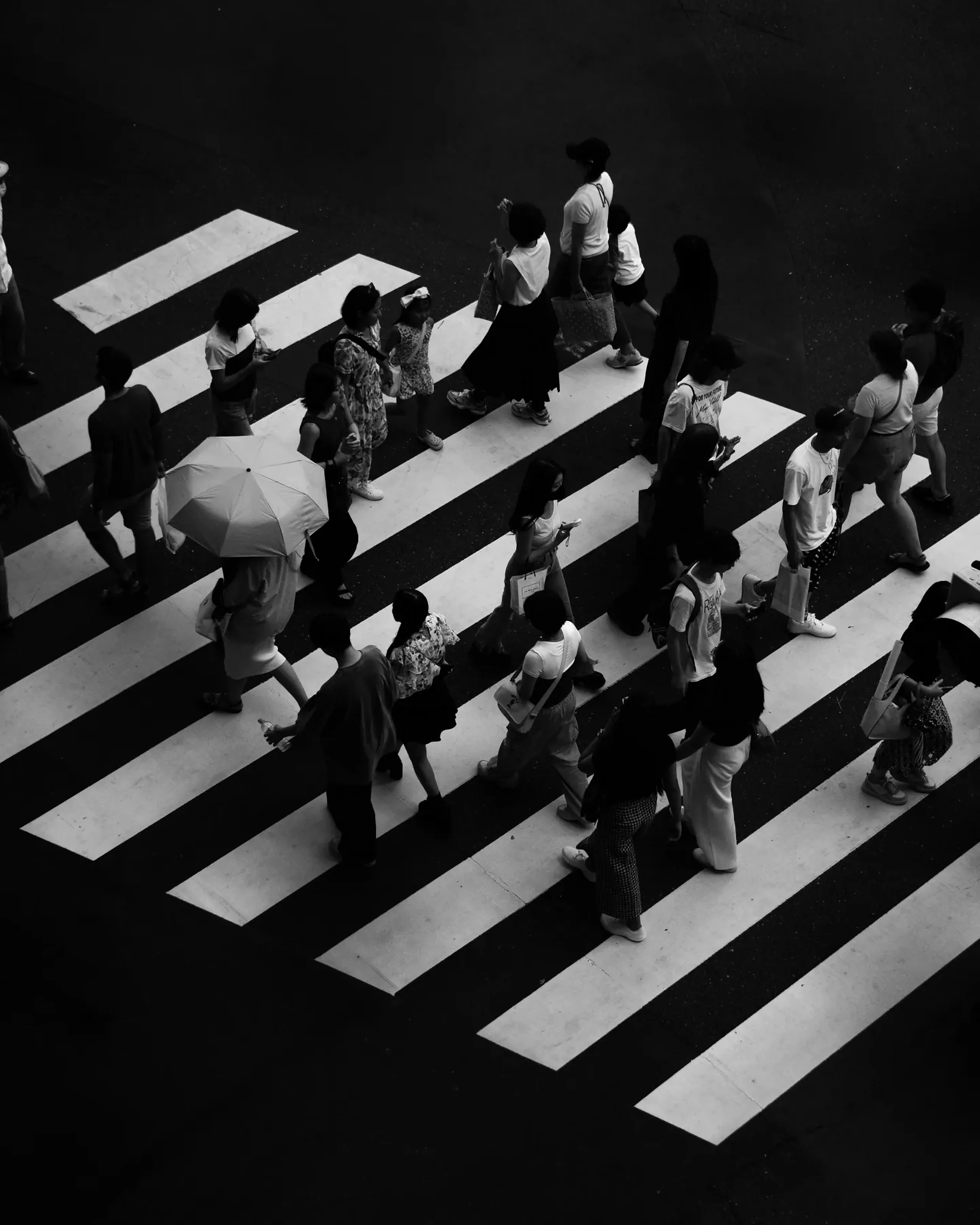 Personas cruzando un paso de cebra, vistas desde lo alto, en blanco y negro